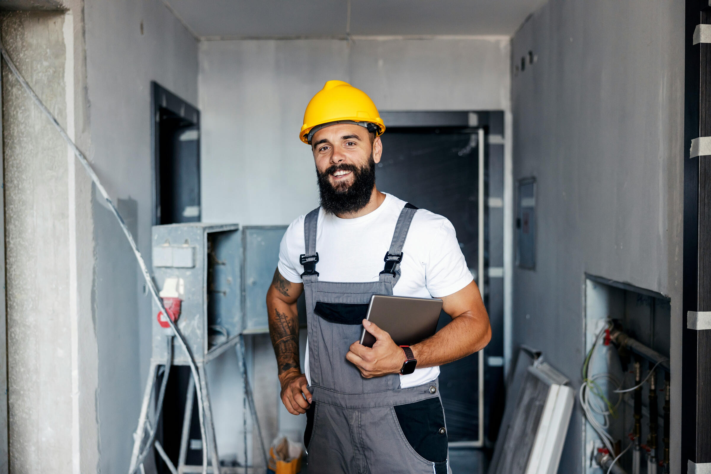 Automated Lead Management for Contractors Friendly residential contractor holding a tablet on a home renovation job site
