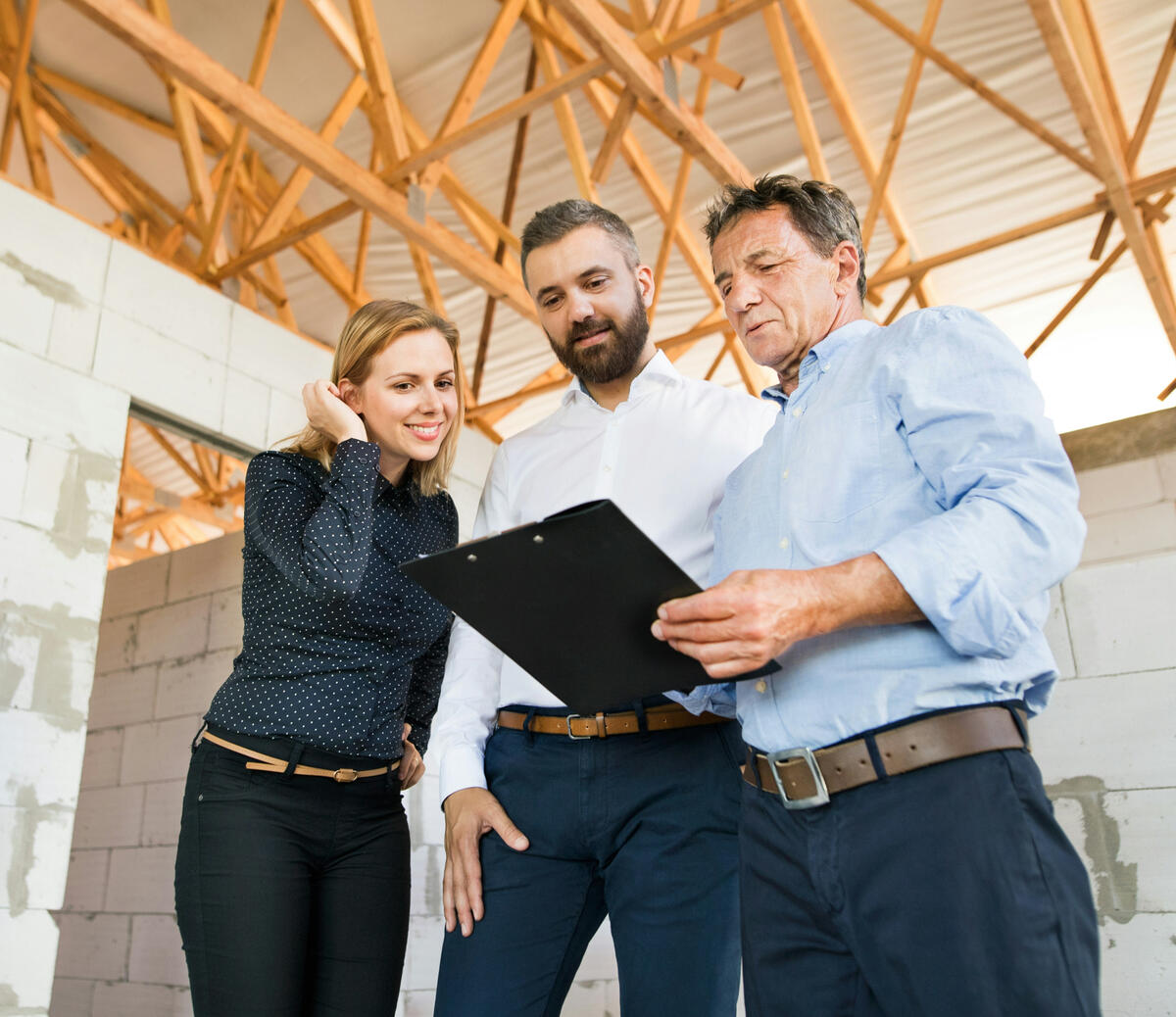 Automated Customer Reactivation Contractor consulting with happy returning homeowners on a new residential build project